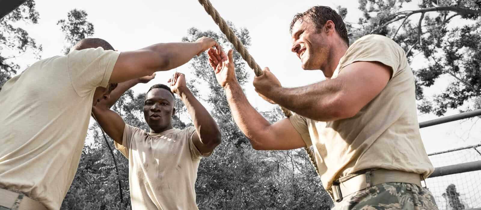 Three US soldiers playing tug of war in their off time