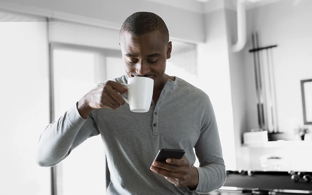 Man sipping coffee after checking his First Command credit card account in the morning.