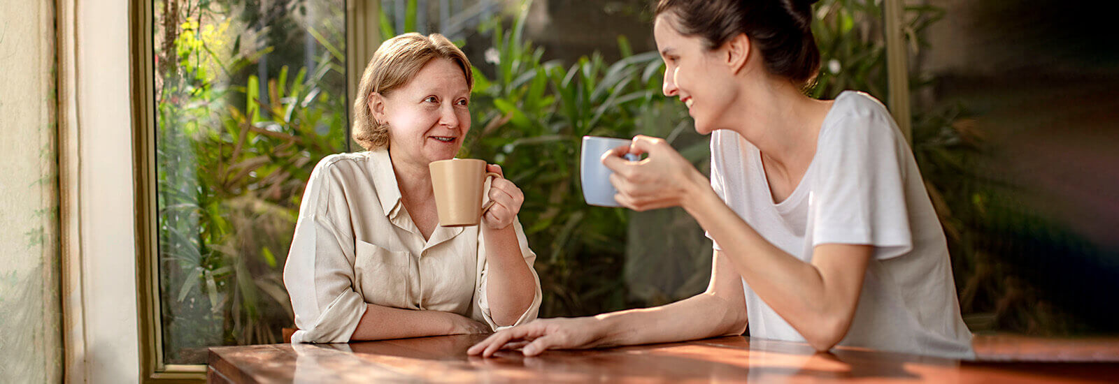 A mother and daughter discuss insurance over coffee.